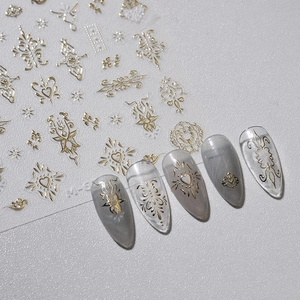 Golden embossed nail stickers with Baroque heart patterns on elegant grey background