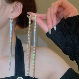 Macro detail of silver long tassel earrings with sparkling cubic zirconia on a model