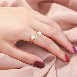 Macro view of gold pearl ring featuring micro-pave zircons on a pink satin fabric