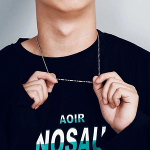 Détail d'un collier en acier inoxydable à perles et barres porté par un mannequin