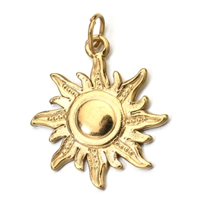 Detailed view of a gold sun-shaped metal pendant with textured rays on a white background