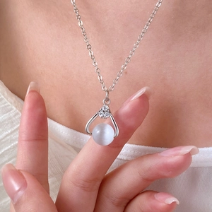 Close-up of heart-shaped moonstone pendant on delicate silver chain necklace