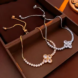 Adjustable gold and silver flower bracelets with sparkling zircons on a luxury jewelry box