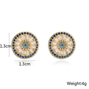 Détail des boucles d'oreilles rondes dorées de 1,3 cm avec zircons bleus et blancs