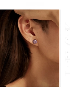 Detail of 8mm violet round cut stud earrings in S925 sterling silver worn by a model