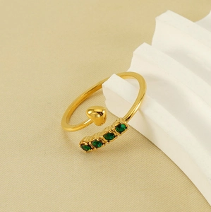 Detail of gold-plated heart ring with four micro-set green cubic zirconia gems