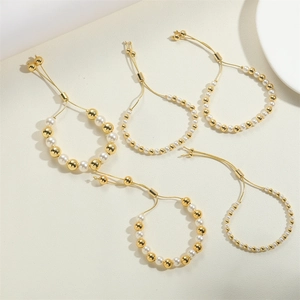 Detail of five-piece gold beaded pearl bracelet set with adjustable sliding clasp closures