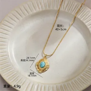 Detail showing turquoise pendant with gold wavy frame on snake chain, 40+5cm length