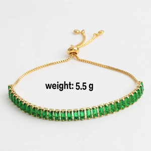 Detail view of gold bolo bracelet with green rectangular zircons weighing 5.5 grams