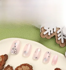 Detailed view of French press-on nails with silver snowflakes, pearls, and star decorations