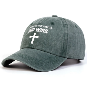 Detail of washed green cotton baseball cap with white cross and religious text print