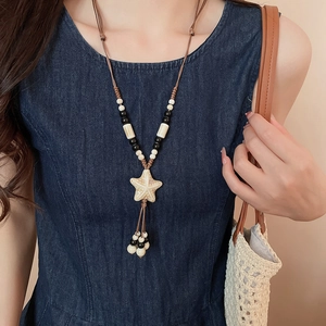 Detailed close-up of a bohemian starfish pendant necklace with ceramic beads on a wax cord