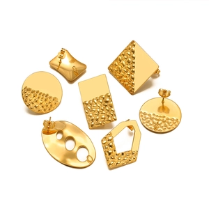 Macro shot of assorted golden geometric earring bases with hammer-textured finish on white background