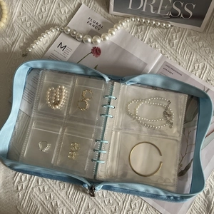 Close-up of light blue jewelry organizer with transparent PVC pockets for earrings