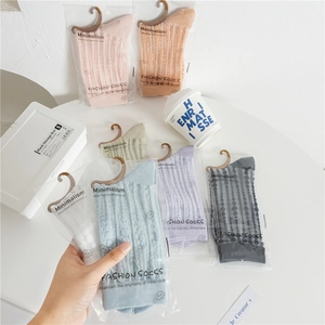 Detailed view of seven pairs of pastel breathable mesh socks in minimalist packaging