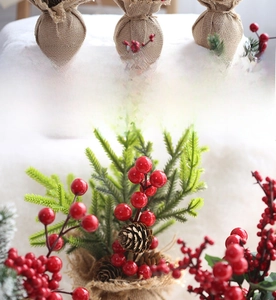 Close-up of artificial red berries and pine needles in a rustic burlap base decoration