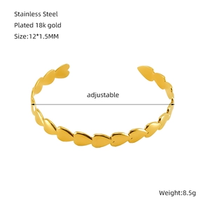 Detailed macro view showing the 18K gold plated heart link on an adjustable steel bangle