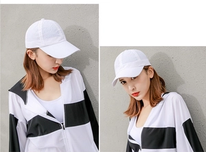 Dettaglio del cappellino da baseball bianco in mesh e giacca a vento sportiva leggera