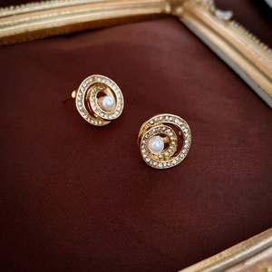 Detailaufnahme von Vintage-Spiralohrringen mit Glitzerdiamanten und einer Perle