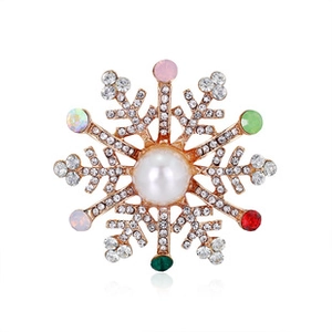 Detailed view of a gold snowflake brooch with pearls and colorful rhinestones