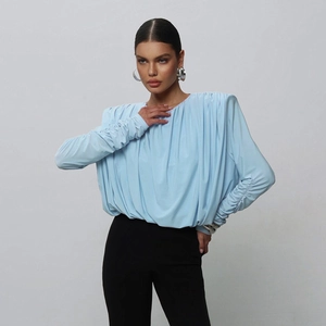 Detail of light blue long-sleeve bodysuit featuring padded shoulders and ruched texture