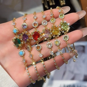 Close-up of 18k gold plated bracelets with colorful zircon gemstones on model wrist