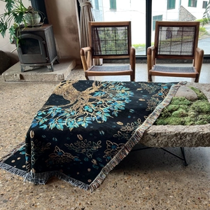 Detailed view of woven tree of life pattern and colorful fringe on a bohemian outdoor blanket