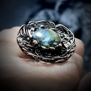 Macro detail of wire-wrapped labradorite stone ring with mystical blue flash on bronze band