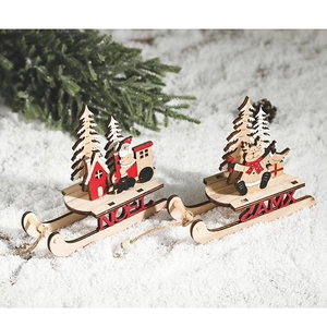 Detail view of laser-cut wooden Christmas sledges with NOEL and XMAS hollow carvings