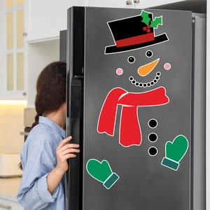 Detailed view of colorful magnetic snowman stickers on a dark gray refrigerator door