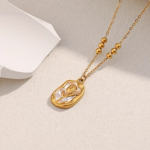 Detail of 18K gold-plated oval pendant with white shell and rose relief on link chain