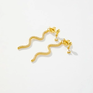 Boucles d'oreilles serpent en argent S925 doré avec zircons blancs sur fond blanc