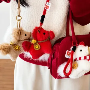 Dettaglio charm da borsa a forma di pony in peluche con sciarpa a righe decorativa