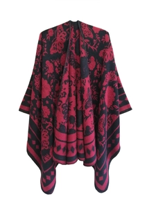 Detail of knitted poncho featuring intricate butterfly and floral jacquard patterns