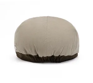 Behind view of retro newsboy cap featuring beige canvas and brown elastic adjustment