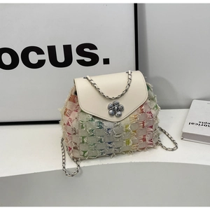 Detail of tweed chain bag with floral metal buckle and white leather flap texture
