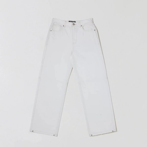 Détail d'un jean blanc à jambe large montrant la texture du coton et les rivets de poche