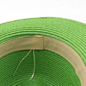 Green straw Panama hat featuring fine weave texture and adjustable interior sweatband
