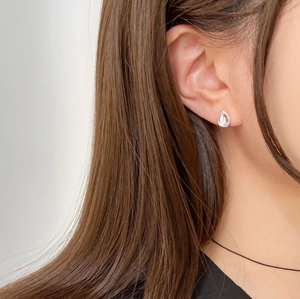 Close-up model view of a silver teardrop earring with iridescent opal stone inlay