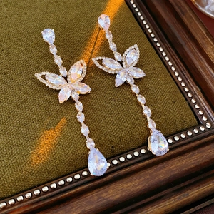Detail view of gold butterfly zircon earrings with elegant water drop crystal pendants