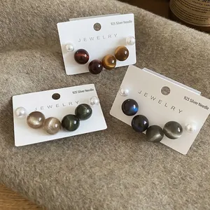 Lot de boucles d'oreilles en argent 925 perles et œil-de-chat sur tissu en laine
