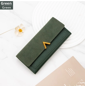 Detail of green long wallet featuring stylish V-shaped gold clasp on marble background