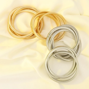 Chic multi-layered elastic spiral bracelets in gold and silver on soft satin fabric