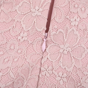 Close-up of pink floral lace fabric with hidden zipper detail on back of the dress