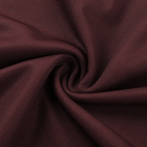 Detailopname van donkerrode mesh-stof met zachte drapering en ademende gebreide structuur