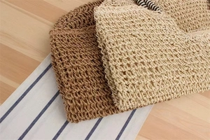 Detailed macro view of handmade woven straw tote bags with striped handle decorations