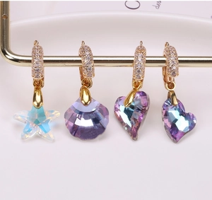 Macro detail of colorful crystal heart and starfish pendants with zircon inlays