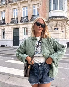 Outdoor street shot of women's oversized green diamond quilted jacket with stand collar