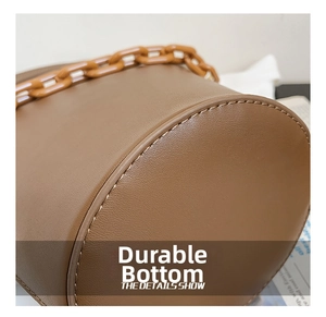Macro detail of the wear-resistant round bottom and leather texture on the brown bucket bag