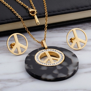 Golden stainless steel peace sign jewelry set with tortoiseshell inlay and crystals